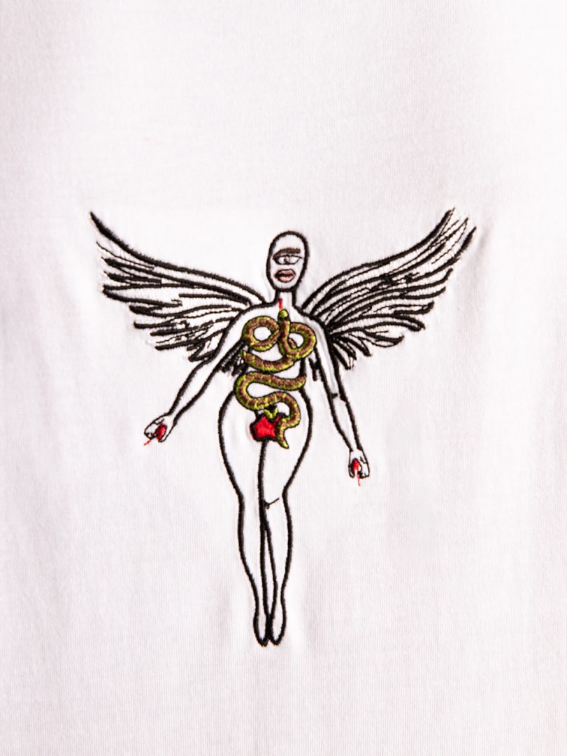 White t-shirt with a black and gold winged figure design on a white background