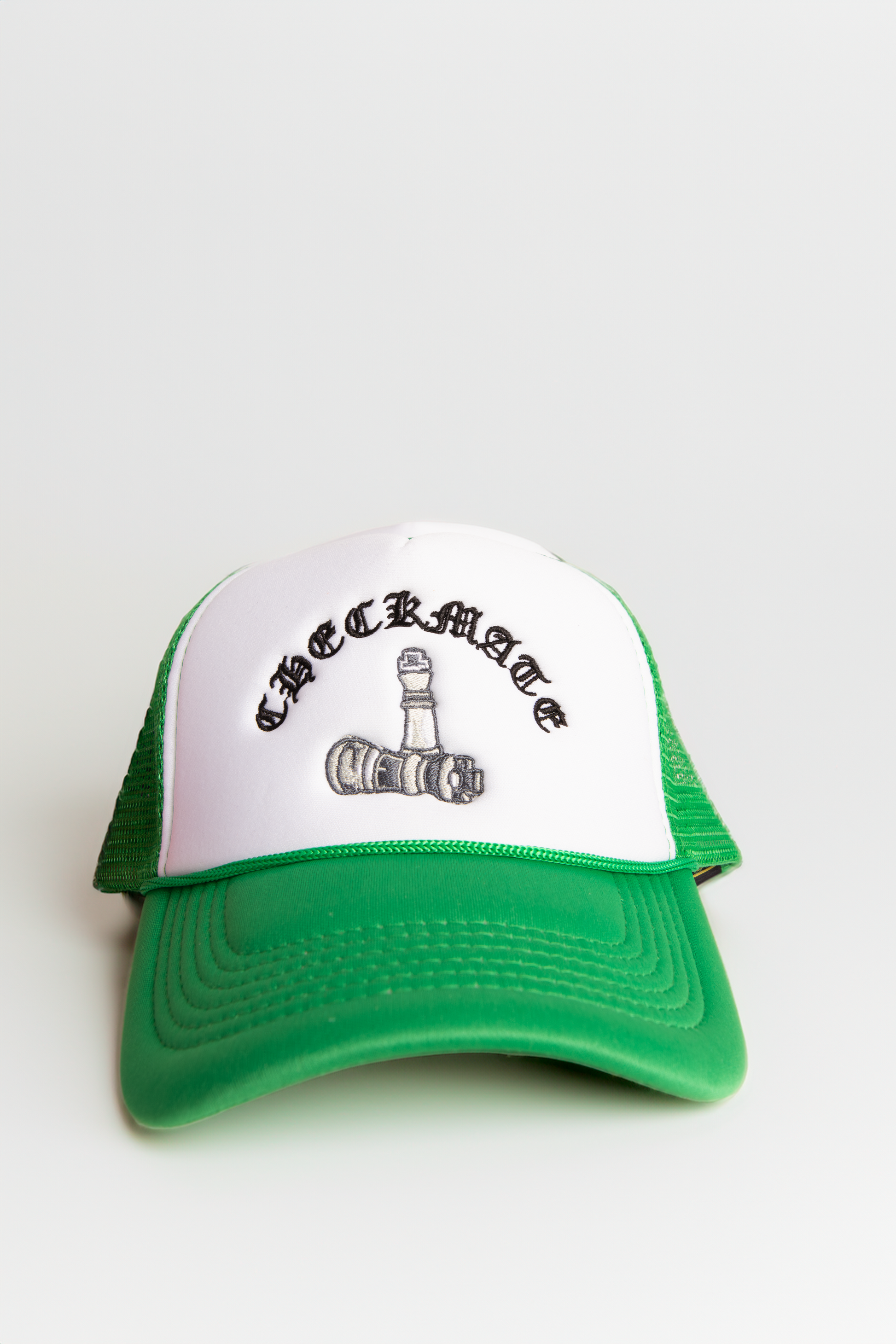 Green and white cap with logo on a light neutral background