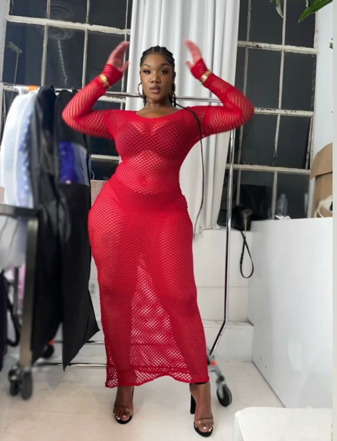 Person wearing a red mesh dress in an indoor setting