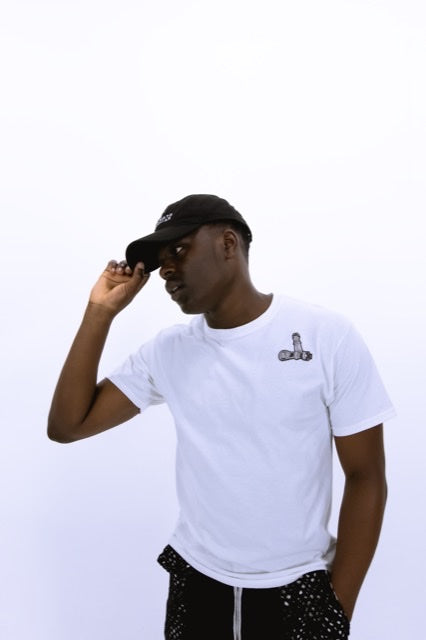 Man wearing a white t-shirt with a logo and black cap on a light gray background