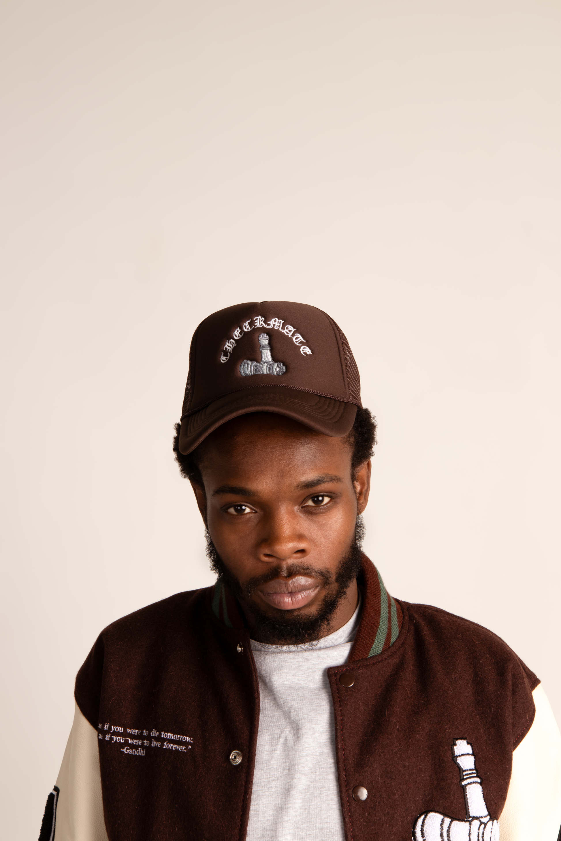 Man wearing checkmate anywear brown trucker and jacket with a white background