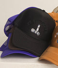 Checkmate Anywear black trucker with a logo on a white surface