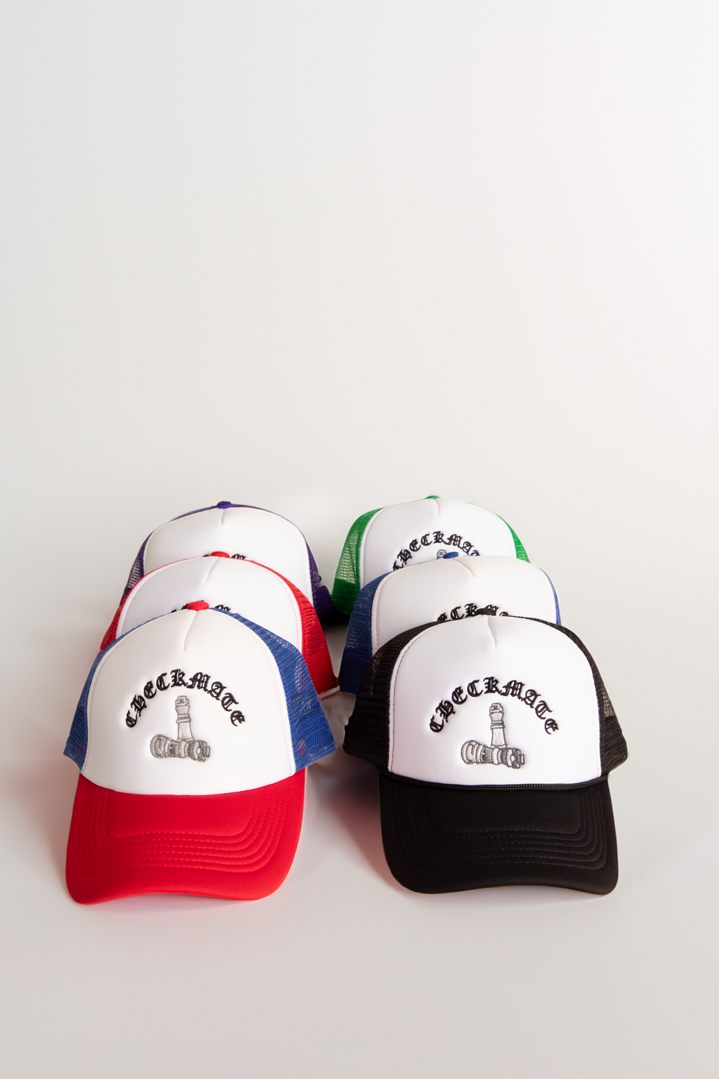 Collection of Checkmate Anywear colorful trucker hats with text on a white background