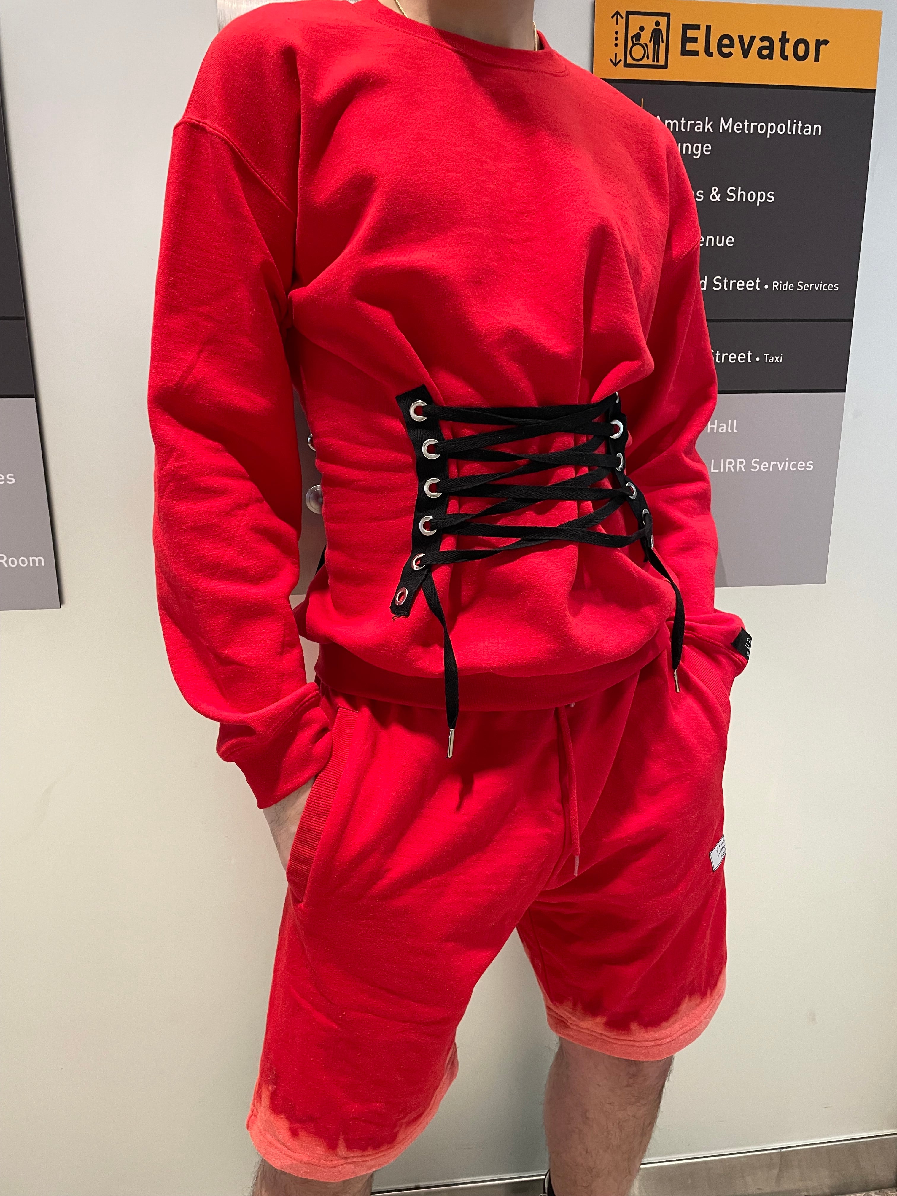 Red drawstrmock corset swarshirt on a white surface